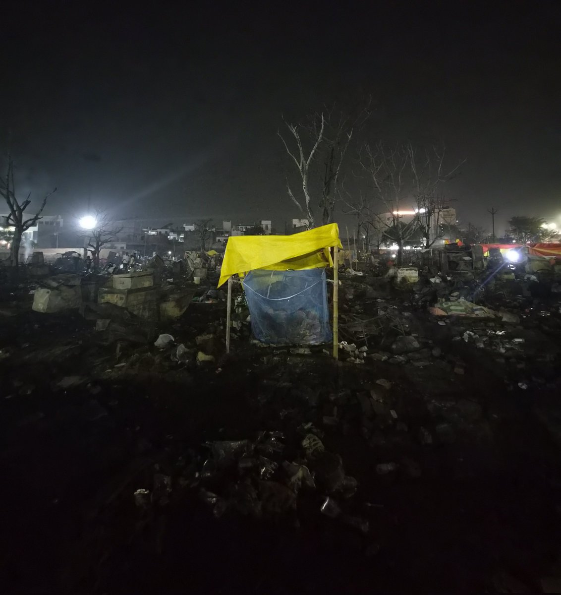 A family sleeping in the middle of charred debris of a slum which was ravaged by fire in Lucknow, Uttar Pradesh.