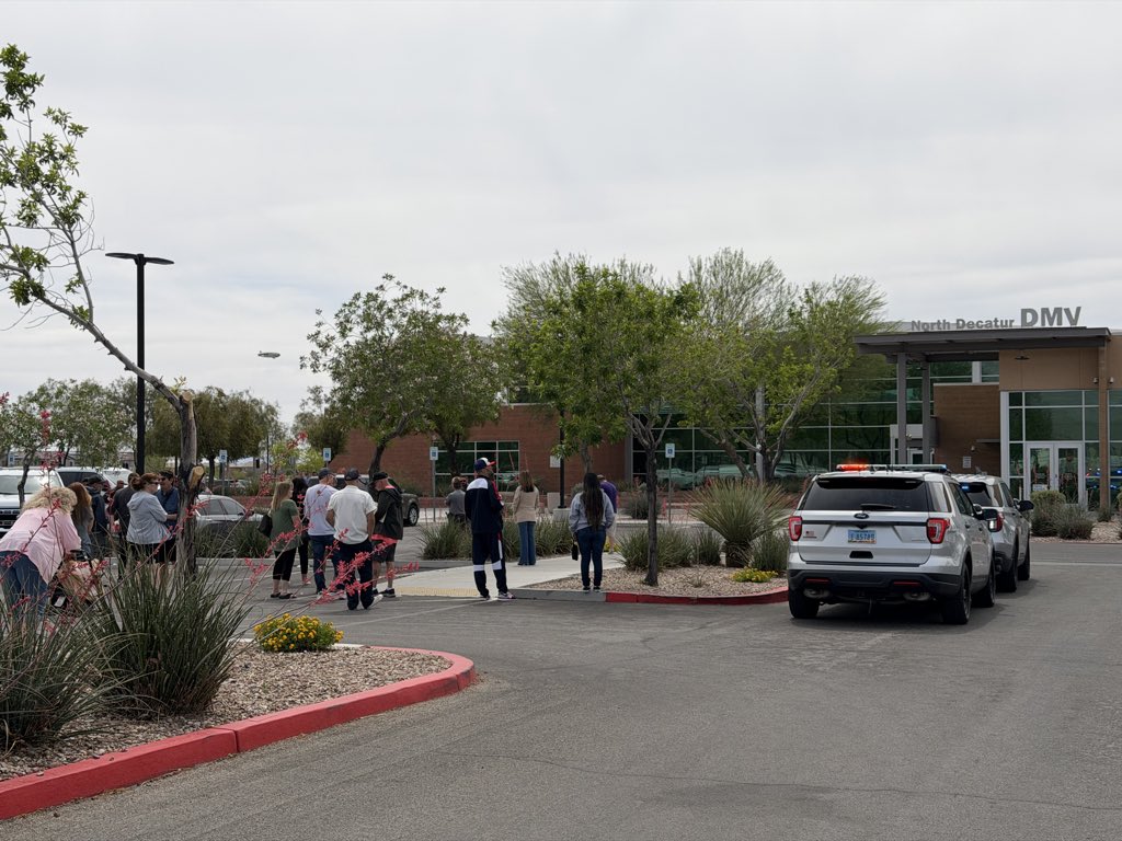 rulerk's tweet photo. A Goodyear blimp hovers over a crowd gathered outside the North Decatur DMV waiting for the bomb squad and police to secure a suspicious bag left inside. https://t.co/kws8DqbeMS