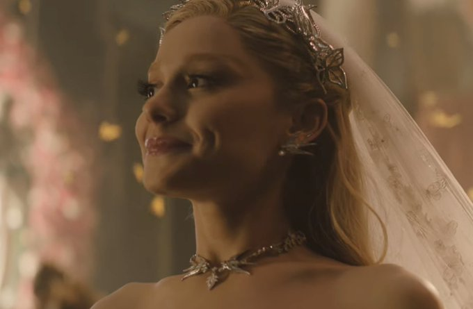 baby glinda smiles like this when she pretends to be happy and satisfied for the sake of pleasing a crowd and then when glinda walks down the aisle she puts on the exact same smile