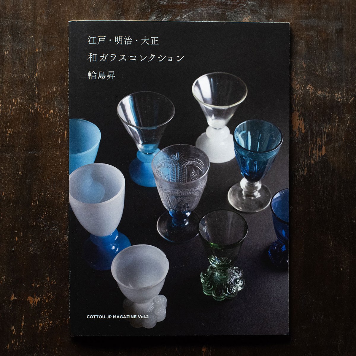 cottoujp's tweet photo. 「江戸・明治・大正 和ガラスコレクション 輪島昇」COTTOU. JP MAGAZINE Vol.2を発売しました。
購入できるのは、COTTOU. JPのサイト。
大江戸骨董市、下落合氷川蚤の市の薬堂のブース。
もしくは、川越成田不動尊蚤の市、高幡不動ござれ市、桐生の天満宮古民具骨董市の輪島さんのブースです。
輪島さんは、掲載品も少しづつ手放していくとのことなので、ぜひも訪ねてみてください。

輪島さんが手放し始める前に、長年のコレクションの記録ができてよかったと思っています。
他にもCOTTOU. JP MAGAZINEでまとめて欲しいコレクションも募集中なので、ぜひお問い合わせください。

------

江戸・明治・大正 和ガラスコレクション
COTTOU. JP MAGAZINE Vol.2
輪島昇

コレクション、テキスト/輪島昇
デザイン、写真、編集 / 児玉 明久 
発行 / COTTOU. JP PUBLISHING 
価格 / 1650円（税込）　※骨董市では1,500円で販売します。

48P A5サイズ
発売日 2026年4月18日 

1980年頃から、ガラス一筋の骨董商「輪島昇」が収集してきた和ガラスのコレクション。

江戸期の切子や吹きガラスの脚付盃、人気の青や乳白色を始めとした様々なリキュールグラス、レース皿（プレスガラス皿）などを掲載。
掲載品はすべて製造年代を記載しています。

・江戸〜大正頃のリキュールグラス、雛道具グラスなどの脚付の小盃を48点
・明治・大正頃のレース皿（プレスガラス皿）を20点
・ガラス製品のカタログ（昭和初期のものを含む）を21ページ分
※製品解説のテキストは2ページのみ収録

-----
輪島 昇(わじまのぼる)

昭和25年（1950年） 北海道函館生まれ。
生家は瀬戸物屋で、小さな頃から大人に混じって新商品の絵柄を選ぶのが大好きだった。

30歳でサラリーマンから念願の骨董屋に。
バブルが終わるか終わらないかの頃で、今はすでになくなってしまった東郷神社や乃木神社の骨董市に出店していた。
その頃が、最も骨董が売れた時期で、珍しい品物もたくさんあって楽しかった。

始めた頃はガラス専門だと言うと、そんなもので飯は食えないと言われたものだったが、ずっとガラス一筋でやってきた。
今もこうしてガラスたちに囲まれていられることを感謝している。
-----