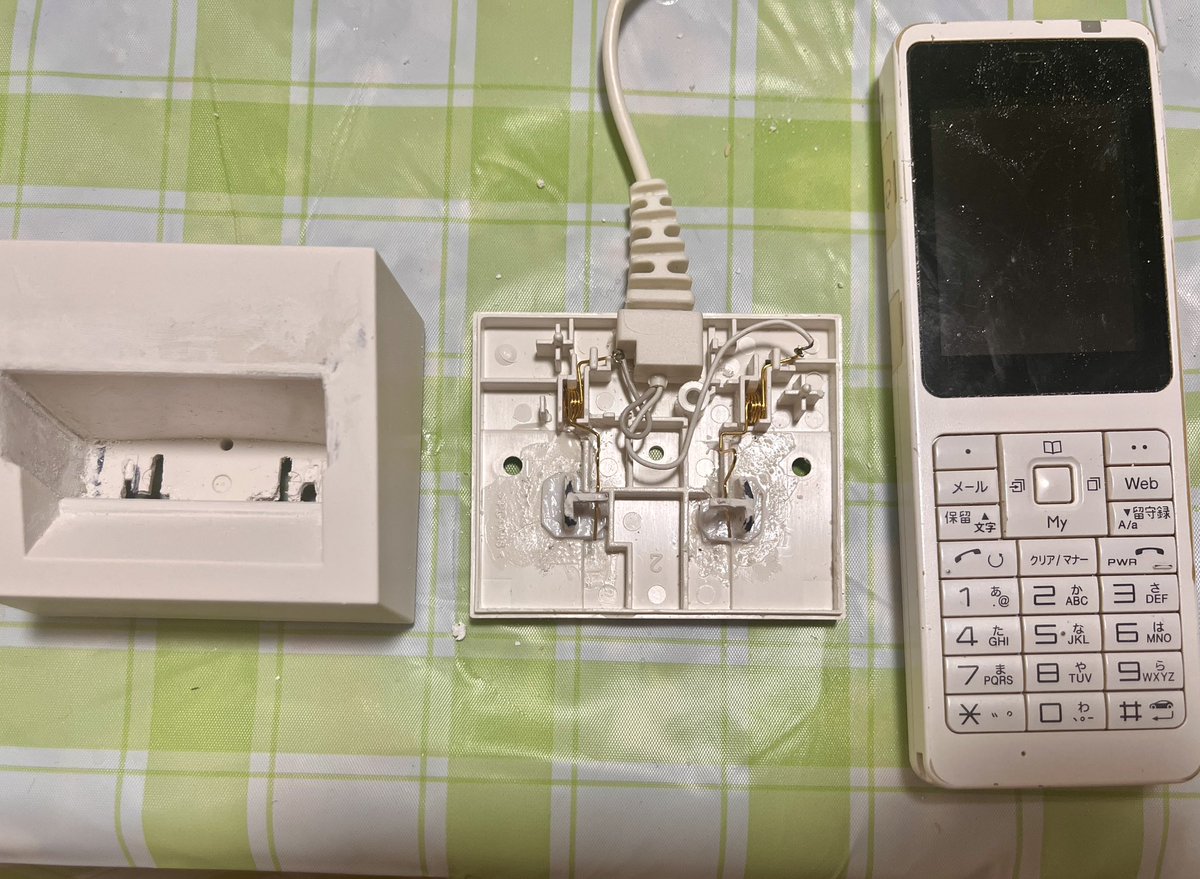 hhkat4's tweet image. おはようございます。
新しい職場から供与されたPHS。
充電台が不足しているそうで、もらえない(~_~;)
→それでは…とメル◯リで格安で似たような台を購入｡
接点の幅寄せ改造、おき台を削って調整中。
うまく充電できますように。
#PHS #充電台　#改造