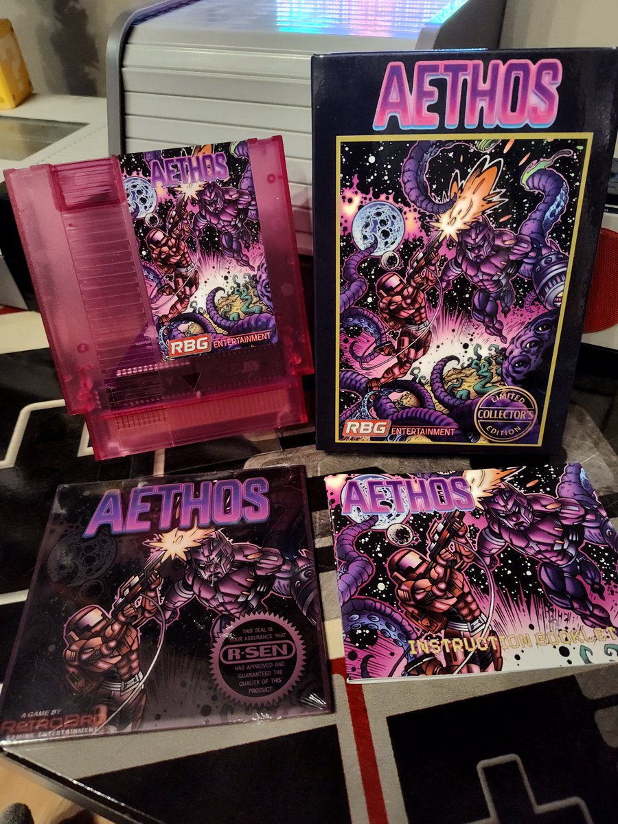 SkoveDog's tweet image. Aethos came today! Too many goodies for one picture. Music CD, poster, magnet, trading cards. And look at the color on that cartridge. Beautiful! @The_RetroBro @DalyenGames #NES #Homebrew