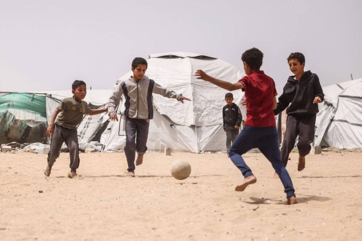GulfTimes_QATAR's tweet image. A beautiful game in the land of mutilated hopes

Children play football amid makeshift shelters for displaced #Palestinians in #KhanYunis in the southern #Gaza Strip on April 18, 2026. 

Since October 10, a fragile US-sponsored #truce in Gaza has largely halted the fighting