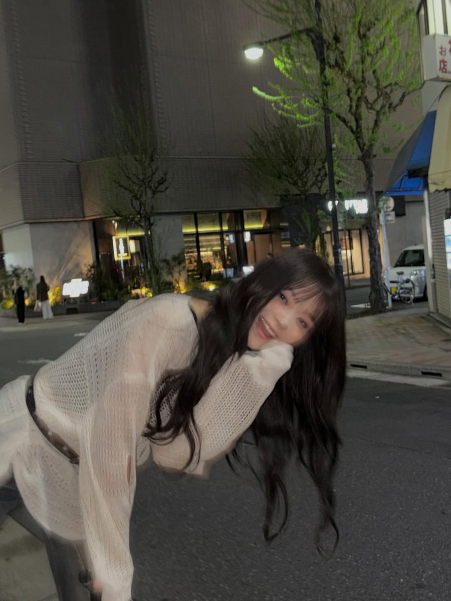 nakyungw's tweet photo. aku membungkuk ke arah kamera sambil menyangga pipi dengan telapak tangan, lalu memberi senyum lebar di tengah jalan kecil yang sepi. gedung sekitarku masih menyala, pepohonan di belakang tampak memantulkan warna hijau dari lampu kota. pose ini jadi penutup manis setelah hari yang padat. lelah tapi aku bahagia bertemu flo. 💫