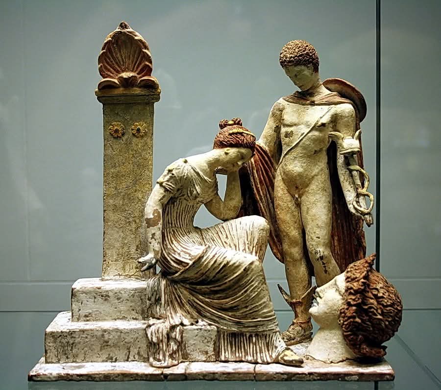 Statuette in terracotta policroma con Ermes il caduceo (bastone alato con due serpenti attorcigliati) lo contraddistingue che assiste una donna in lutto seduta su una tomba. IV sec. a.C