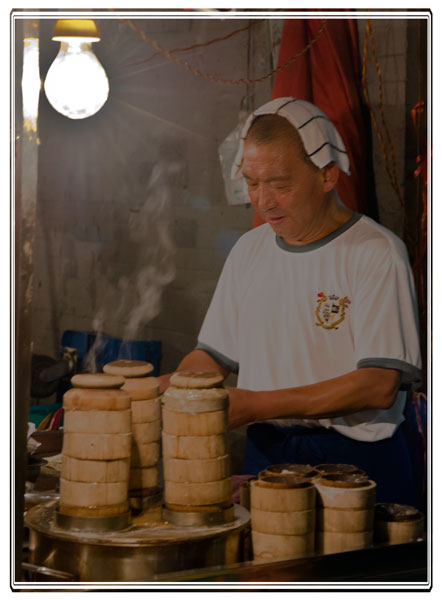 photos_dsmith's tweet image. A #baozi (#Chinese #dumplings) maker keeps cool on his stand with a wet towel. Steam rises though the #bamboo vessels gently steaming the baozi until cooked #China #food #streetfood #streetfoods #streetfoodlover #PictureOfTheDay for more see darrensmith.org.uk