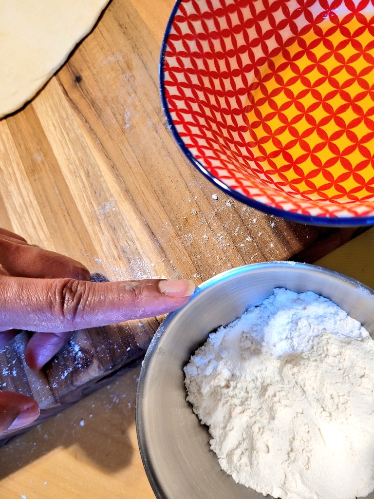 cellswordrin's tweet image. It is good to find your rhythm 👩🏾‍🍳 like in all things you put focus into, rhythm is key. Here, I have a little bowl of Olive Oil and another small bowl of Flour for rolling the dough. One hand is to oil the rolling pin and the other hand is to Flour the board. #Foodie #Cooking