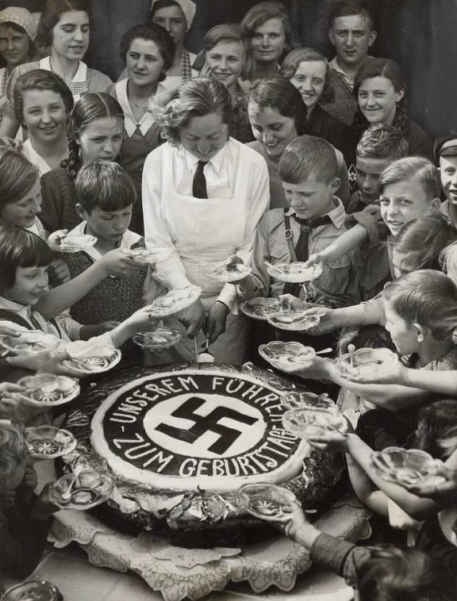 Orphaned children receiving cake on Hitler's birthday. Berlin, 1934