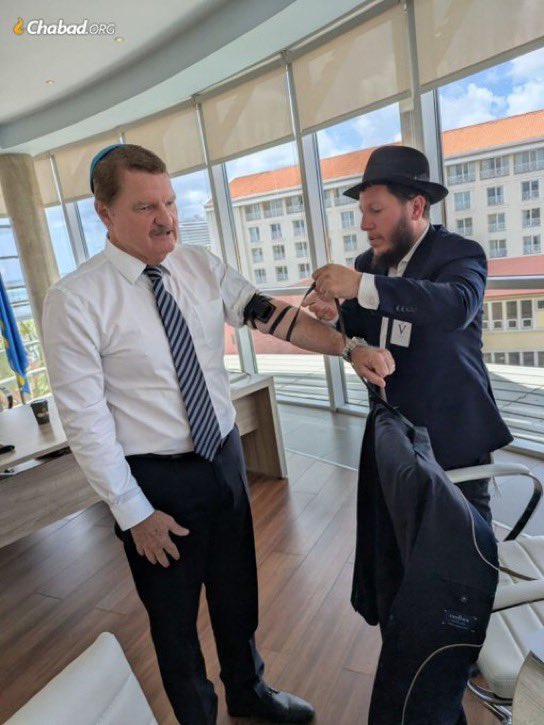 FarroYossi's tweet photo. Mike Eman, the Jewish Prime Minister of Aruba, wrapping tefillin in his office together with the island’s local Chabad rabbi. https://t.co/pQrtbLnF7c