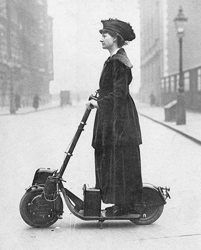 Woman riding a very early scooter, 1916.