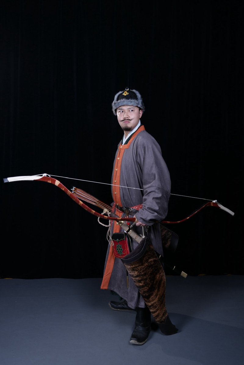 明末军士戎服像
明末清初之际，大梢弓的形制已逐步趋于规范，明清两代的大梢弓在核心构造与力学原理上实则一脉相承，并无本质分野。
搭配明细：
鞑帽
对襟长袖罩甲
开叉式直裰
大梢弓
马刀
明样刀子
革包
弓囊箭袋
感谢曾哥ArcherVIGE 制作并提供的清中期风格角弓
#明朝 #明制汉服 #明制武备