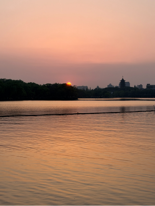 FancyNHuu's tweet photo. The sun dips below the skyline over Jiaxing Nanhu. The water turns to liquid honey and paints the world in warm amber tones  ���� #Nanhu #Jiaxing #GoldenHour https://t.co/rRvETjNgVg