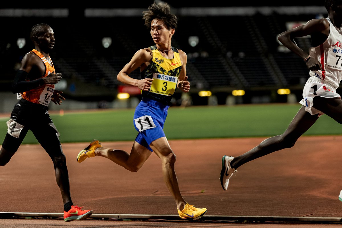 EKIDEN_News's tweet photo. 山口智規、日本人初の5000m12分台への道
金栗記念の最終組5000mを13分16秒38の自己ベストで走り終えると、山口智規はトラックに倒れ込んだ。そこへ鈴木琉胤、増子陽太も続いて倒れ込む。しばらくして息を整えると、山口はスタスタとこちらに歩み寄り、親指を立てた。

「そうか、もうWじゃない」

早稲田大のWポーズを撮るのが、これまでの流れだった。これまで、いろんな場所で、トモノリ選手のWポーズを撮ってきた。早稲田大学を卒業し、国内初戦はNIKEのプロユニ。胸にはSGHのロゴがあった。

写真を撮り終えると
「最近のEKIDEN NEWSはどうかと思ってましたよ。
　他の選手ばかり取り上げてて、
　今回の金栗記念はどう考えても俺でしょう！」
と、いたずらっぽく笑った。

つい、世間並みの見方をしていた自分を恥じた。その日のスポーツニュースで大きく伝えられていたのは、好走したトモノリ選手ではなく、同じレースを走った三浦龍司の方だった。そうだ。その通りだ。トモノリ選手。すまん。

「山口智規がエグいことになっている」
オーストラリア・メルボルンTCでの練習を見た人たちは、口を揃えてそう言っていた。中長距離のトラック種目で、日本記録を上回るタイムで走る選手たちがいる中でも「山口が練習でも先頭を引っ張ってるんですよ。無理をして前に出てるんじゃなくて、動きにも余裕があるんです。」TWOLAPSの横田真人コーチの目は確かだ。

駅伝、ロードシーズンを経てトラックのシーズンインを金栗でする大半の選手とは違い、トモノリ選手は駅伝を終えると、早々に温かい南半球へ飛び、春先から全力で走れるよう備えてきたのだ。「ここから日本選手権へ向けて調子をあげていきます」という選手らとは一線を画している。

「本当はここで12分台を出すつもりでしたけど　ペースメーカーがつかないと聞いたので　12分台はここじゃないなと。　だから、金栗に合わせて練習してないんです。　やったのは坂ダッシュだけ。」

全世界で記録が一気に伸びてきたことで、これまで優位性のあったケニア・エチオピア出身の実業団ランナーであっても、五輪や世界陸上の参加標準記録は高い壁となってしまった。特にケニア出身の選手たちは5000m13分一桁くらいまでスピードをつければより稼げるマラソンへと移行する傾向がある。彼らとしても13分一桁くらいのタイムは喉から手が出るほど欲しいタイム。誰かを引くくらいなら、自分も走りたい。そんな事情もあってペースメーカーがつかなかった。

この日は、序盤は塩尻和也がスタートから先頭に立った。それでもケニア勢は前に出ない。塩尻が後退すると、序盤から2番手につけ、早稲田大の後輩2人を引いていた山口が前に出てスピードを維持し、レースを動かした。日本人選手でその後を追える者はおらず、山口の後ろにケニア勢が続く。ラストに入ると、後ろでためていたケニア勢が一斉にスパートした。つまり、山口の作ったペースを使ってタイムを出す。そうした背景が如実に表れたレース展開だった。

この13分16秒38はペースメーカーについていってようやく出せたタイムではなく、自分でレースを動かしていく中で出したタイム。それだけに、数字以上の価値をもつ。

もう、12分台で走れる感覚はある、ということ？ と聞くと、「ええ。出しますよ。12分台は」

続きはこちらへ。
山口智規、日本人初の5000m12分台への道｜EKIDEN NEWS @EKIDEN_News https://t.co/l0IxE6PuM4