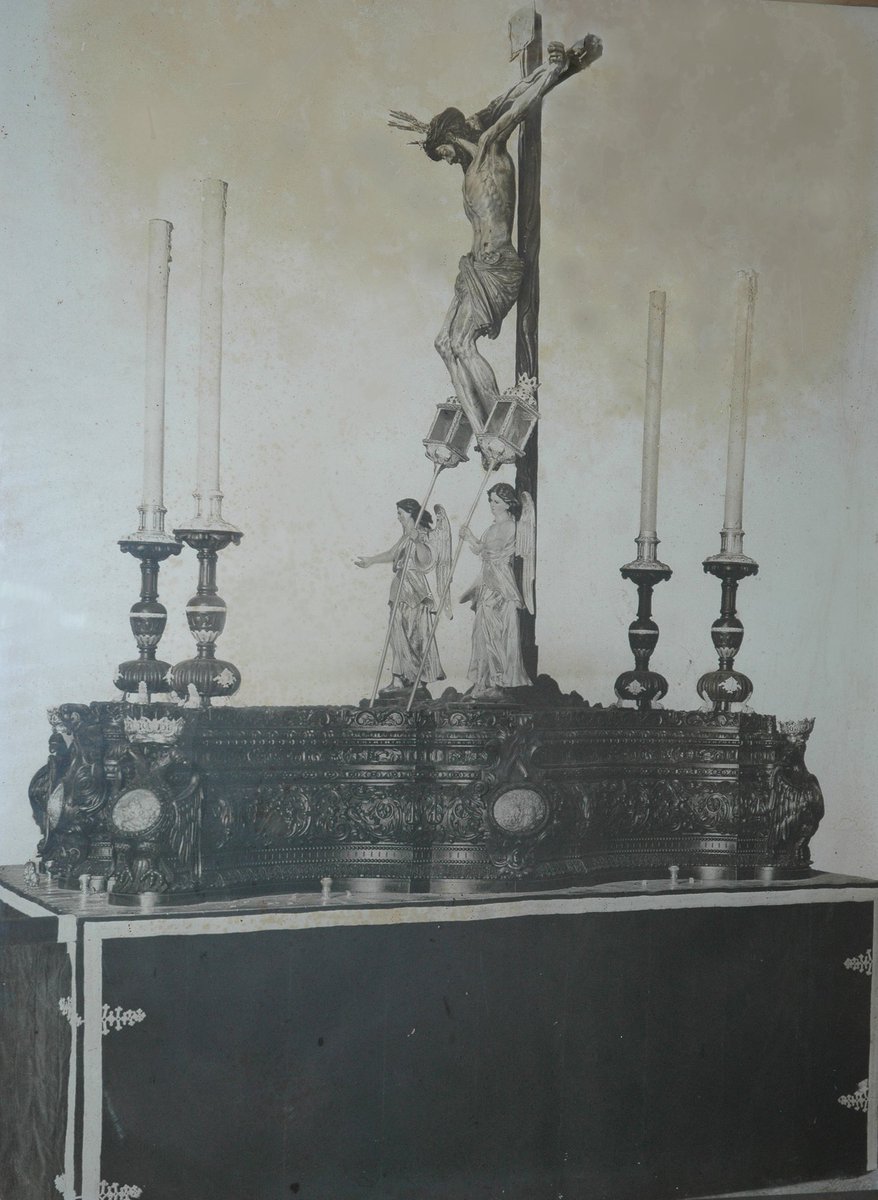 Viernes del Calvario. Si desde 1895 el Cristo salía en un paso neogótico dorado, en 1909 se estrena el paso de caoba iluminado por cuatro hachas de cera escoltado por ángeles que mostraba una profunda severidad acorde con la imagen del crucificado. 📷 restaurada p Carlos Sánchez