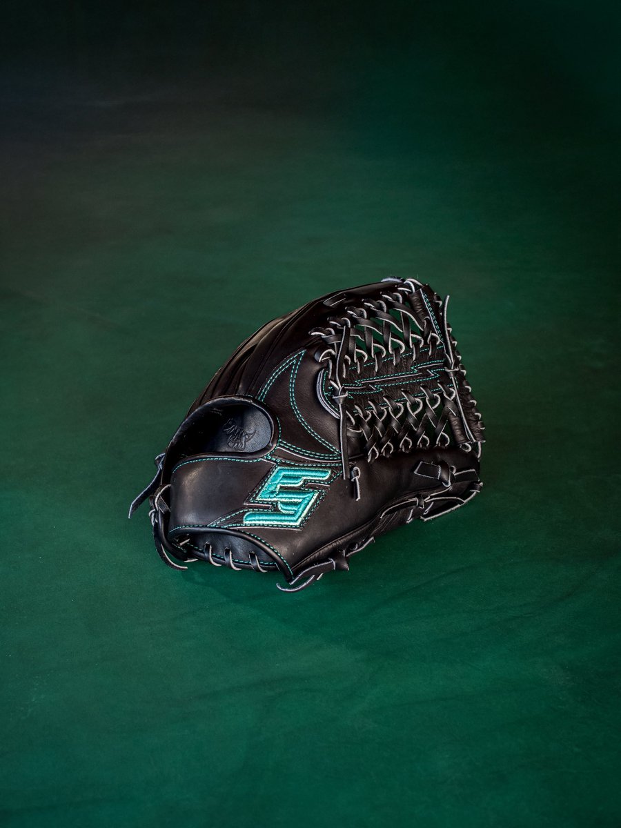 5年の積み重ね、その先へ。Primal Scale Embossed Leather×Emerald Turf Labelを纏った限定グラブ。野性味あふれる鱗模様レザーが唯一無二の存在感を放つ。  ラベルはFIVEのブランドカラーとフィールドに広がる芝生をイメージした特別な証。FIVE 5周年モデル、5月5日発売。FIVE取扱店にて。