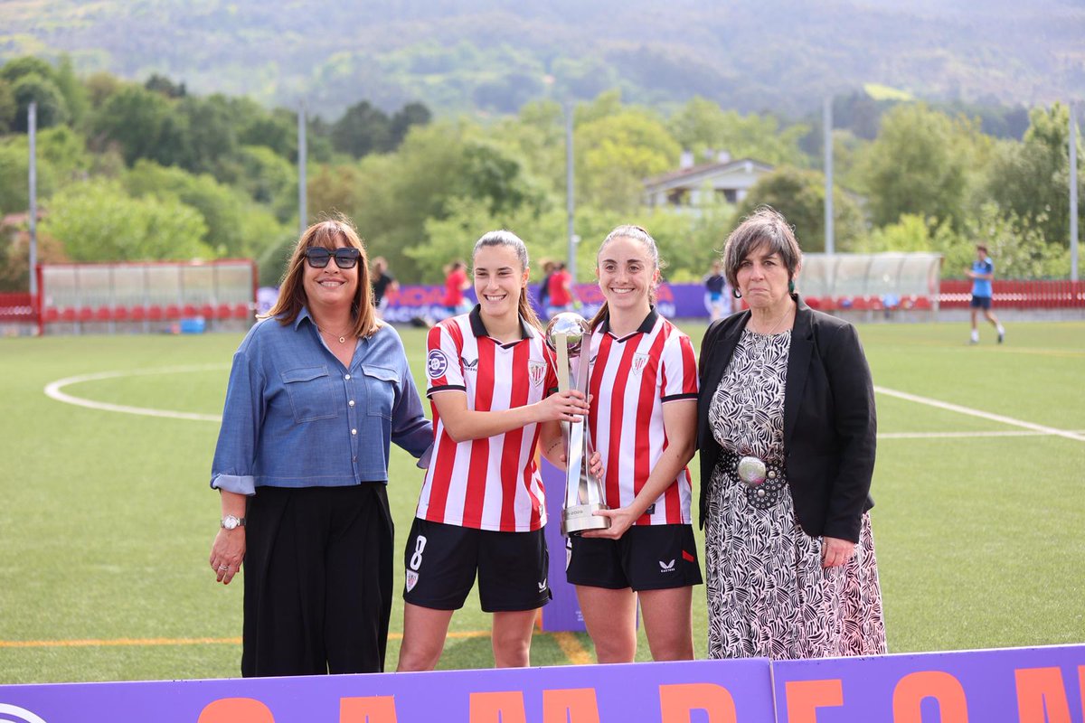 AthleticClubFem's tweet photo. 👏  El #AthleticClubFem B cierra una gran temporada con otra victoria (3-2) en casa junto a l@s athleticzales.

Ana Guzman, vocal de la RFEF y Miren Goiriena, responsable del Fútbol Femenino de la @EFF_FVF han entregado el trofeo a las leonas por proclamarse campeonas de la Segunda @FutFemRFEF.

😍 Mila esker @Bizkerreft pasilloagatik!

#AthleticLezama 🦁