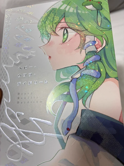 例大祭新刊【ヘビー・ウツツ・デイドリーム】 装丁紹介 表紙はカバーをつけてます。 トムソン加工で早苗さんが見えます。 カバーはビオトープ ミッドナイトブルーに、 パール箔で印字しています(文字や模様は全部箔です)