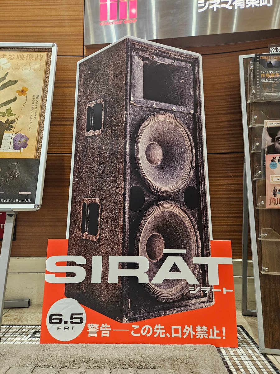 htc_yurakucho's tweet photo. ／
映画『#シラート』のスタンディが #ヒューマントラストシネマ有楽町 に登場いたしました🏜️
＼

失踪した娘を探し、父と息子が行き着いたのは、現実と幻覚が混濁するような野外レイブのカオス。

耳をつんざく重低音、
赤い照明の海、
沈黙を貫く父親の背中――

6/5(金) 公開📢 https://t.co/ZzuF0YWnTs