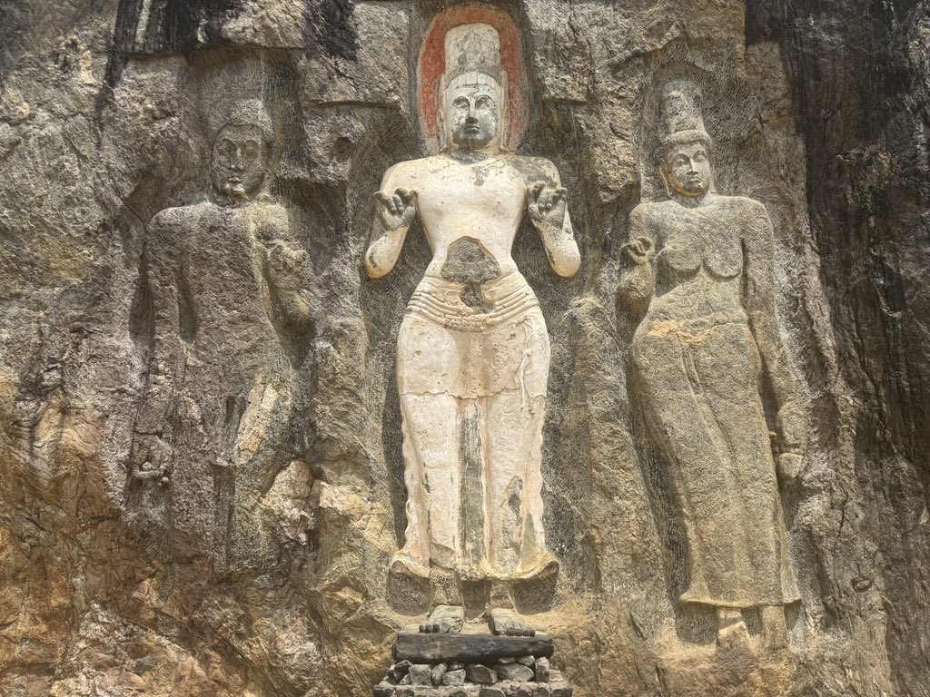 Been thinking about Buduruwagala lately.. that massive rock carving that just sits there in Wellawaya, watching centuries roll by.

Seven Buddha statues carved into a single rock face. The tallest one? 51 feet high. Just standing there since the 9th or 10th century.. making every
