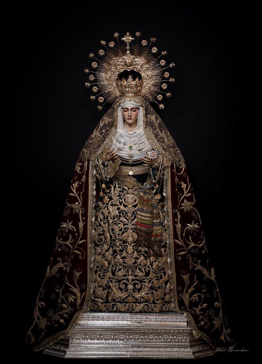 SoyDeLaVeraCruz's tweet photo. Sobre el tocado se prenden gran profusión de antiguos broches y prendedores con formas florales, vegetales, de estrellas y de estilo Cartier. En el centro del mismo, destaca antiguo ópalo en forma de tondo de oro y pedrería verde. Engalana su cuello antiguo collar de perlas naturales y oro así como otro, doble remata el pecherín.

Porta en su mano derecha antiguo pañuelo de encaje dorado, sendas cadenas y antiguas medallas de oro con la efigie de Nuestra Señora de las Angustias, Patrona de la ciudad de Granada y su archidiócesis y cadena de oro y ágatas verdes con la imagen del Santísimo Cristo de la Vera-Cruz.

En sus dedos, antiguos anillos de estilo isabelino de oro y zafiros.

En su mano izquierda, porta la rosa de pasión de oro, plata rubíes, zafiros y rosas de Francia así como sendas cadenas de oro con las efigies de la Virgen de Lourdes y S.S el papa Juan XXIII. En sus dedos, solitario de oro y brillante, anillo con perla cultivada y zafiros blancos.

Esta misma esencia es la que ha reproducido, con su profesionalidad y buen hacer, D. Joaquín Gómez, apoyado por el equipo de vestidores de María Santísima y los priostes de esta Hermandad.

Cristo de la Vera-Cruz, redentor nuestro, Dios en Alcalá, acuérdate de tu misericordia para con tus fieles y no nos abandones. Te imploramos con la mediación de nuestra Bendita Madre de las Angustias.
Toma tu Cruz y sígueme.