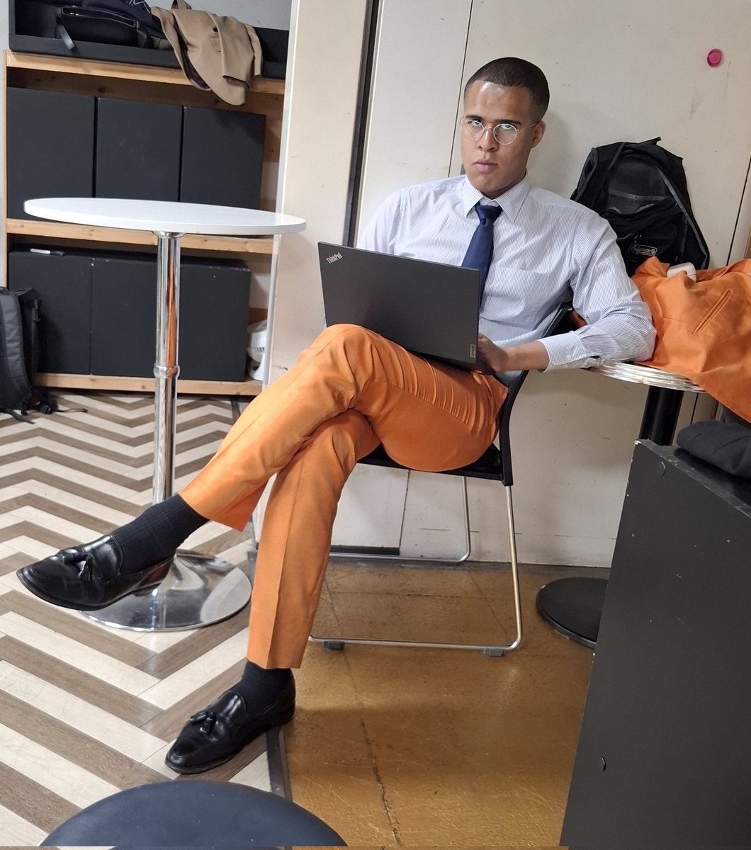 アメリカの囚人服みたいな色のスーツだな…