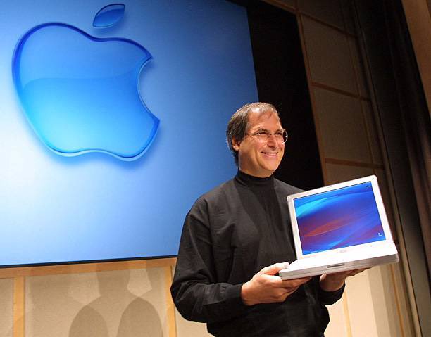25YearsAgoLive's tweet photo. Apple Computer CEO and co-founder Steve Jobs holds up an all new iBook notebook computer weighing just 4.9lbs (2.2kgs) during an Apple Media event in Cupertino, California. https://t.co/GHQOUpXyoZ