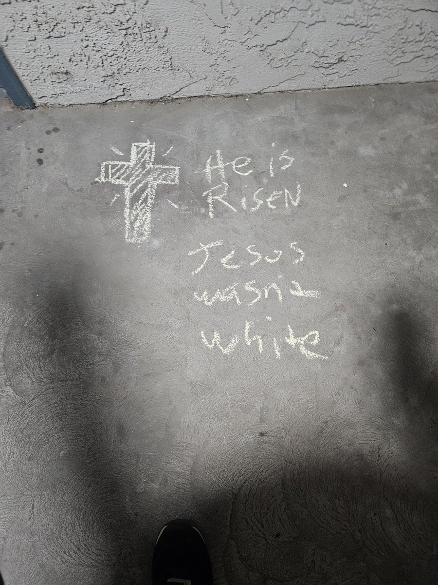 MisterCapable1's tweet photo. Amazon driver delivering to me. I have a chalk drawing on the floor near my door of a crucifix with "He is Risen" written since Easter. This guy picks up my kids chalk and writes  Jesus wasn't white" for no reason. He doesn't know me. I forgive him, but i am not happy. https://t.co/JXoOIKEhm7