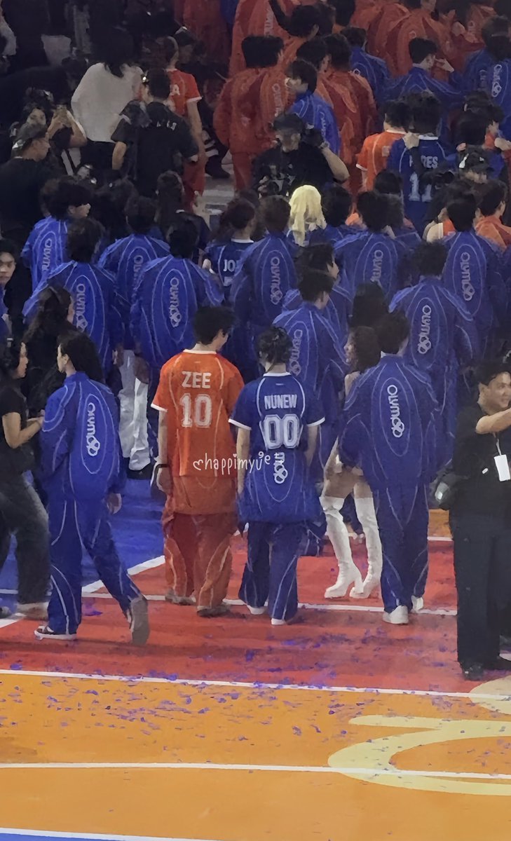 In a sea of covered names, everyone disappeared beneath the blue of their jackets everyone except them.
“ZEE” and “NUNEW” remained uncovered, walking side by side as if the night itself refused to let their names be hidden from each other.

Maybe it was coincidence.
Or maybe some