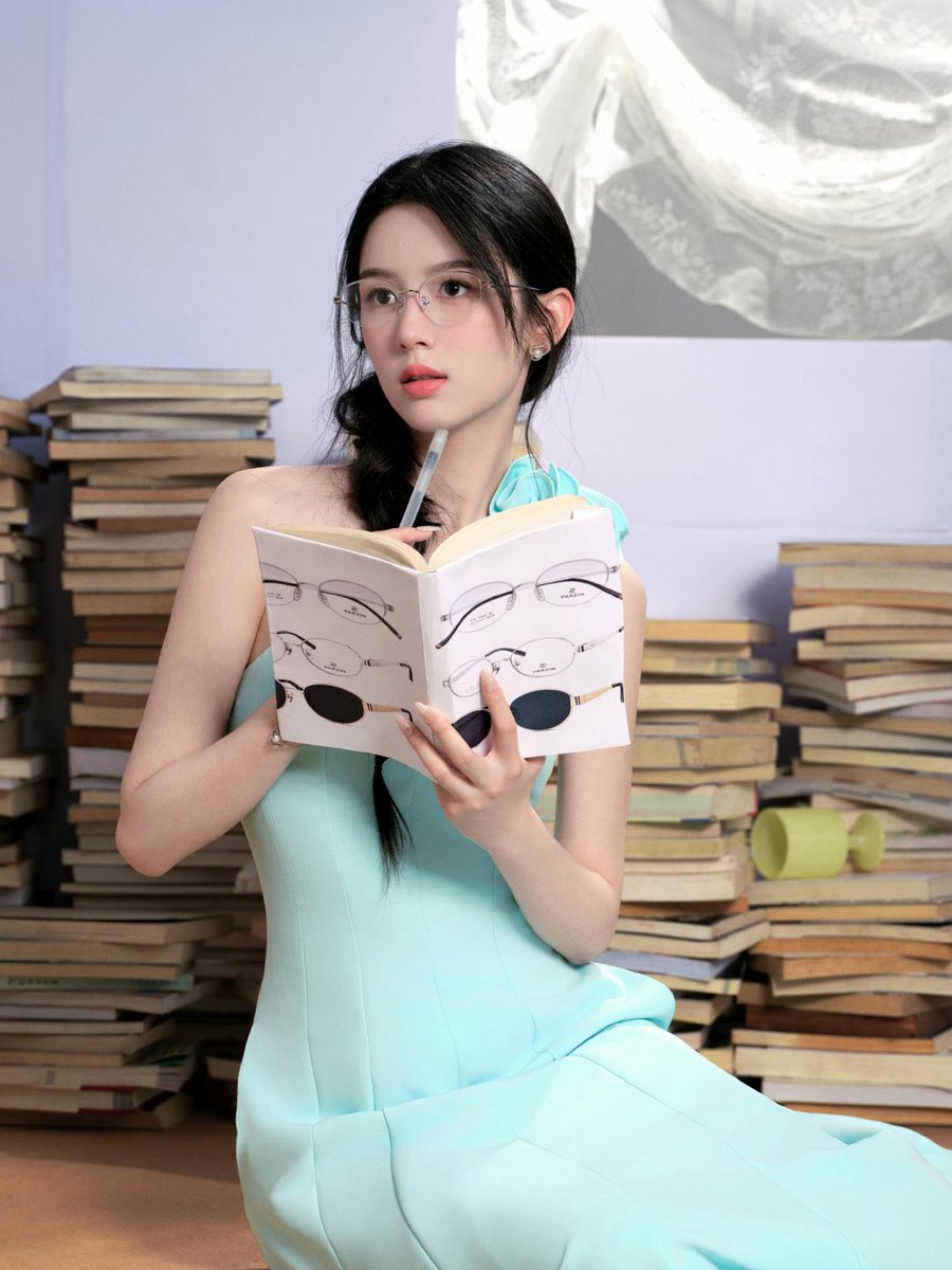 zhouuyeah's tweet photo. Summer arrived softly on her shoulders, carrying the scent of paper pages, warm afternoons, and quiet wonders beneath the sunlight. With books stacked beside her like trusted companions, she looked as if she belonged between the lines of a novel written for golden days. https://t.co/936iNhXzbU