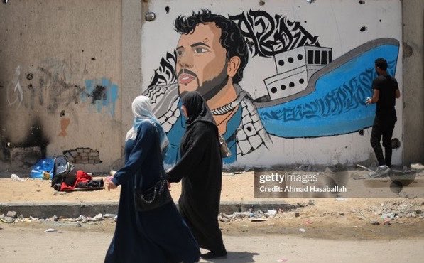 swilkinsonbc's tweet photo. Artist Abu Al-Qarshli paints a mural of @gbsumudflotilla’s Thiago Ávila on a wall in Gaza: a hero etched in Gaza's memory, says @yyasaryyavuz https://t.co/TD3fxDvMjJ