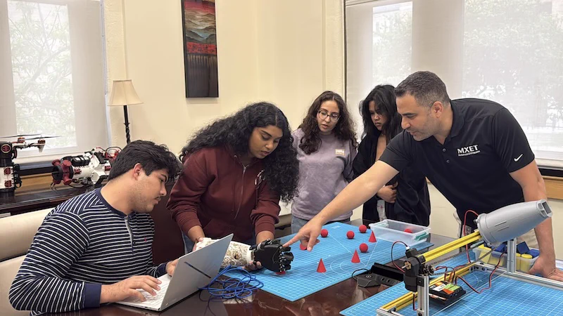 Mohamed Gharib coaching students on a project.