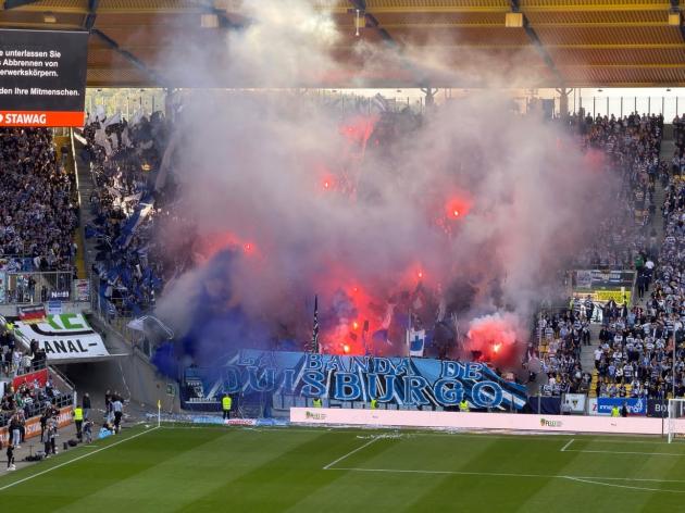 FasziFankurve's tweet image. Im ausverkauften Tivoli setzten die Gäste aus Duisburg ein „La Banda de Duisburgo“-Transparent am Zaun mit einem Chaos-Intro in Szene. Mehr zu diesem und weiteren Spielen unter ➡ faszination-fankurve.de 📷 @groundhopper520 #choreo #pyro #tifo #ultras #fans #msvduisburg