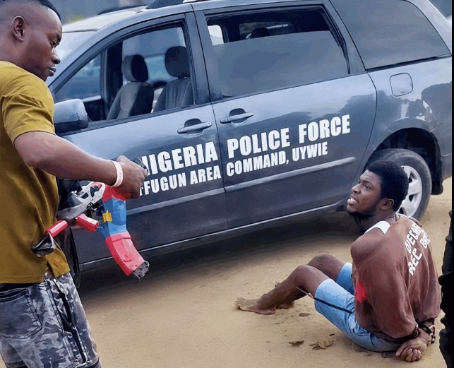 THE VERY SAME THING MEANT TO PROTECT AND SAVE US IS KILLING US! —😭

ASP Nuhu Usman grinning next to a tied-up Mene Ogidi... then he pulled the trigger anyway.

Yes, the suspect was caught smuggling a loaded Beretta — but executing a restrained man begging for his life is still