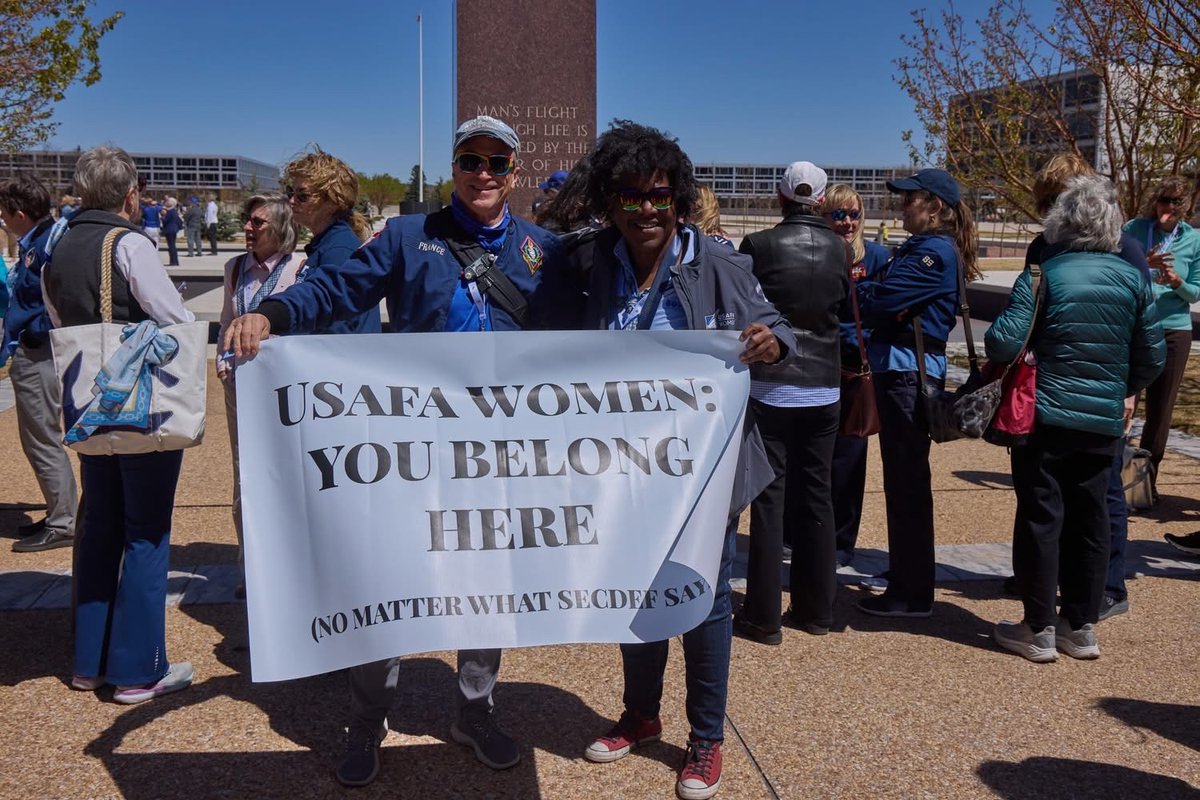 STARRSmission's tweet photo. STARRS received this new photo and comment as a follow-on to the previous one @RealLToddWood wrote a story on. "The fellow in the blue A jacket is Martin France, class of 81. O-7 retired. Former head of the Astronautical Engineering Dept at the Air Force Academy. He actively protests USAFA, the USAF, and the current administration. My guess is he created this banner that was displayed during the 50 years of women at the service academies. His behavior politicized and demeaned women who served."

STARRS has a lot of articles about his activism, including him protesting in front of USAFA--in his uniform--for transgender cadets. 
@RealLToddWood @HoneyBadger_USA