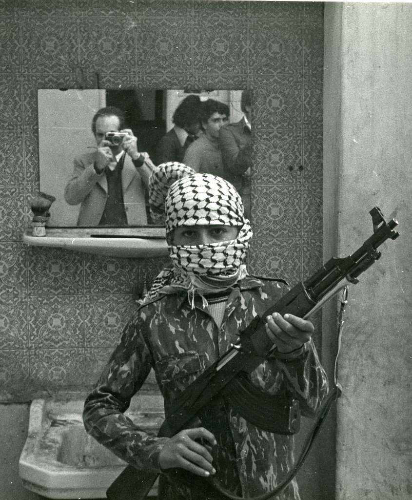 piebyfour's tweet photo. A photograph of Italian artist Bruno Caruso photographing a PLO guerrilla fighter holding an AK-47 in Beirut, Lebanon, 1976. https://t.co/cdiYeNBGFr