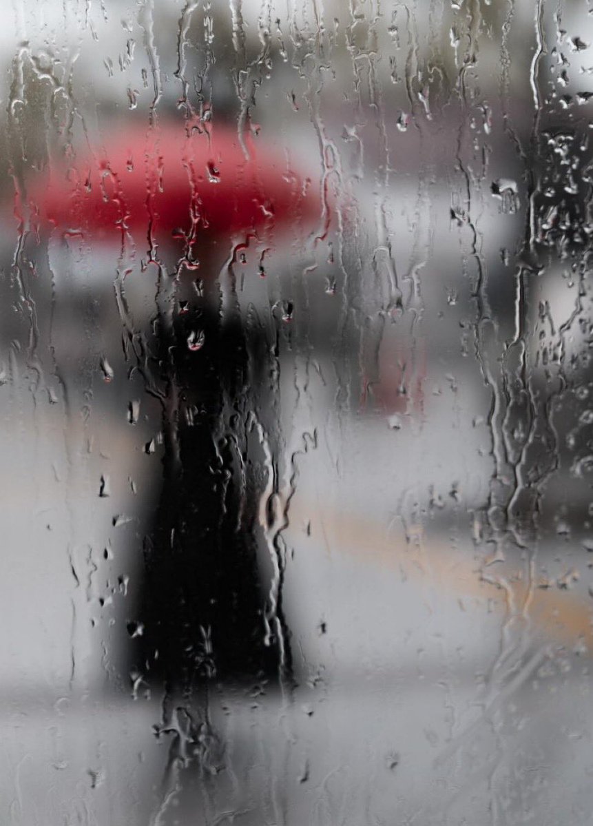 shaleenrakesh's tweet image. Rained Out #Voyuerism #Essay 

Rain crashes down—it challenges the pavement, gray static blurring the city’s sharp lines into something slippery. From my car, the street’s a blur of hunched shoulders, wiper swishes, heels slapping puddles. Then—bam—a red umbrella pierces the