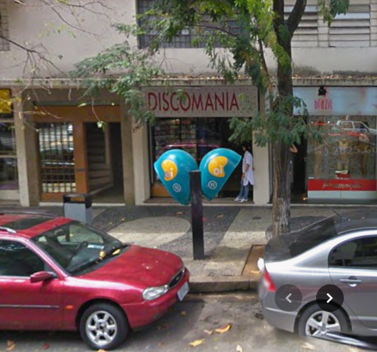 2009. Numa rua qualquer, dois orelhões em frente a uma loja de CDs.