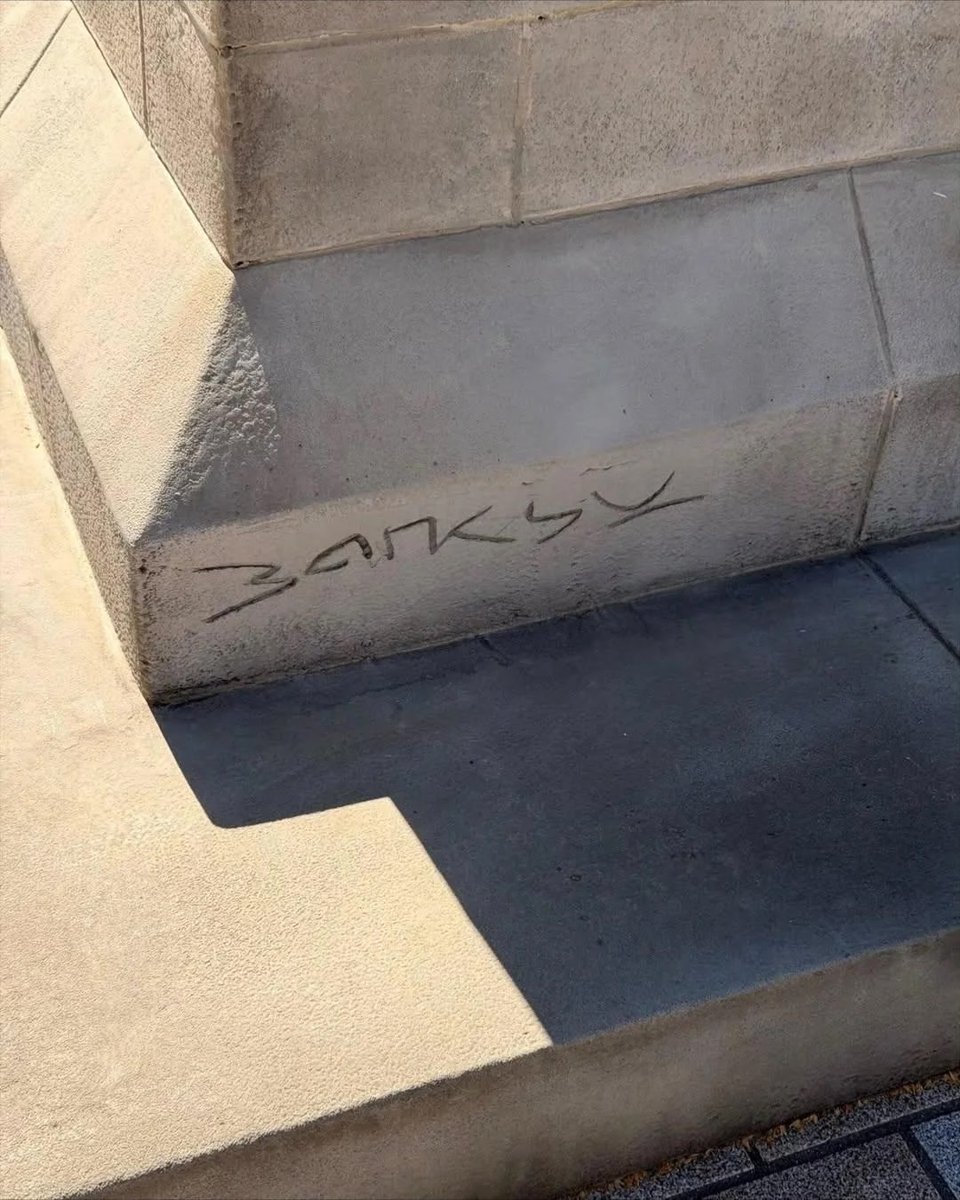 🇬🇧 Вчера в центре Лондона на Waterloo Place появилась скульптура, которую приписывают Banksy — мужчина в костюме уверенно шагает вперед, уже ступая за край постамента. В руке он держит древко флага, полотно которого полностью закрывает ему лицо и развевается, как будто ослепляя