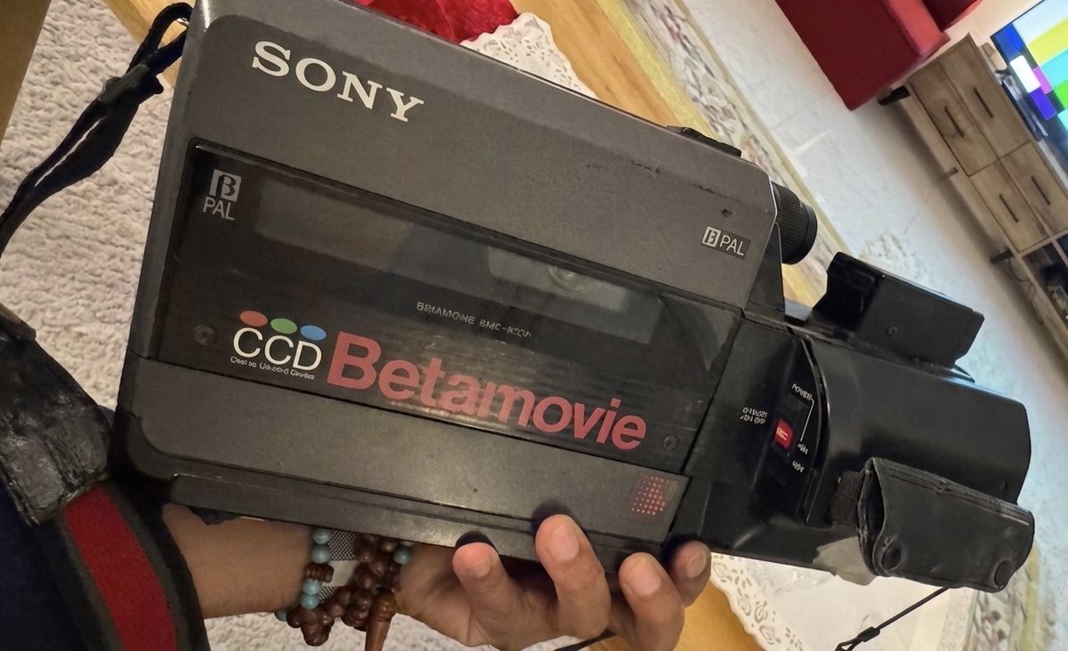من يد الوالدة -الله يحفظها- ليدي.. هنا كانت البداية.

هذه التحفة هي Sony Betamovie، أول كاميرا "كامي كورد" في العالم، من مواليد عام 1983.

ما كانت بالنسبة لي مجرد آلة تصوير، كانت الباب اللي شفت منه العالم بعيون مختلفة. تعلمت فيها كيف أمسك اللقطة، وكيف أحفظ اللحظة قبل لا تروح. مرت