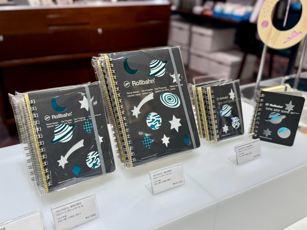 smith_kwsk's tweet photo. 「メルタ」シリーズの直営店限定デザインは宇宙モチーフ。
こちらのデザインのみ箔押しが施され、特別なメタリックの色紙を使った工作のようなかわいらしさ。リングやゴムバンドも色を抑えているので型抜きのデザインがより際立ちます
#ロルバーン #rollbahn https://t.co/KUnvuW1LPP