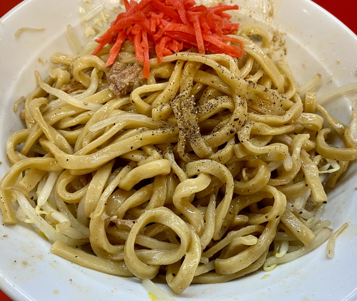 今日の麺活🍜＃ノックアウト小松川店 定訪。
汁なし(ゆで前300g)にんにくしょうが(普通)
とろ丸チャーシュー、、🍺
魚粉と削り節が効いた濃厚なスープが柔らかめな平打ち幅広麺によく絡んで褐色に染まり塩っぱ旨い！箸で持ち上げるだけで崩れるとろ丸は脂好きには堪らない！黒胡椒と追い紅生姜で完食😋