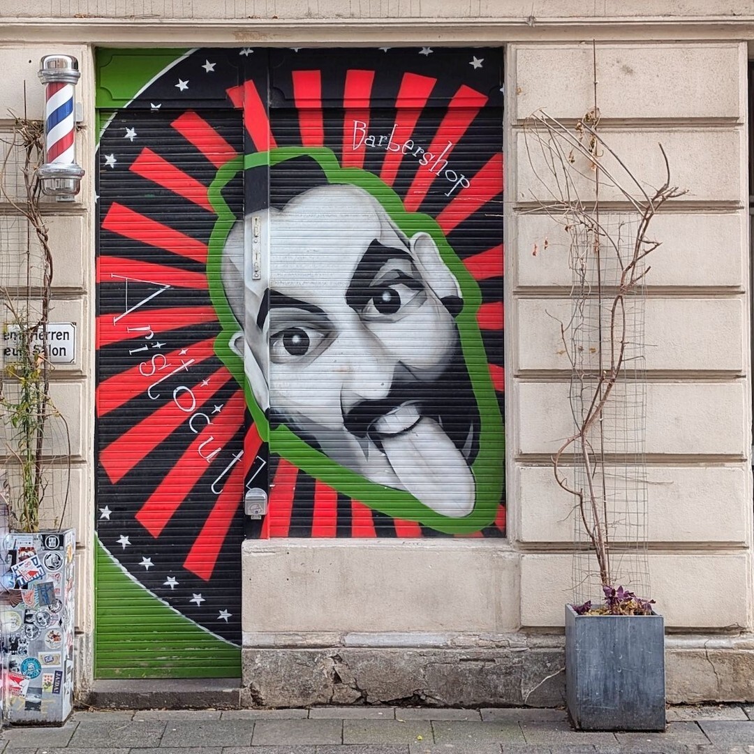 SidewalkSafari's tweet image. Covered barber shop door with street art in Cologne, Germany. instagr.am/p/DX1UF8EH-xc/