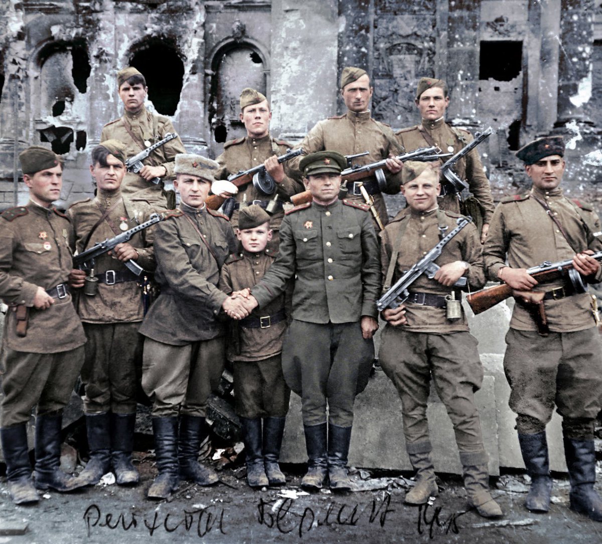 Берлин. 2 мая 1945-го. На ступенях "фашистского логова" бойцы 756-го полка 150-й Идрицкой стрелковой дивизии. В верхнем ряду, справа – разведчики Михаил Егоров и Мелитон Кантария, водрузившие Знамя Победы над рейхстагом. А в центре нижнего ряда 14-летний сын полка Жора Артёменков