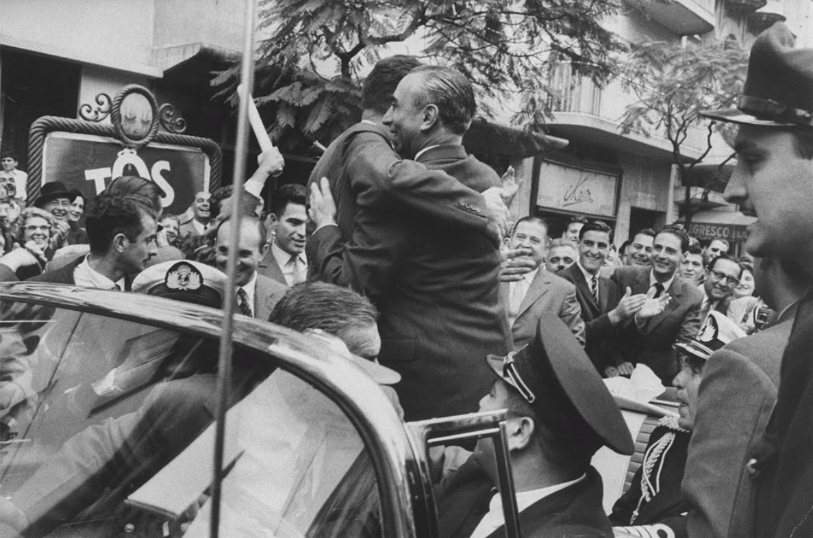 El almirante Isaac F. Rojas, vicepresidente de la Nación, y Richard Nixon recorren las calles de la ciudad de Buenos Aires en un vehículo descapotable a finales de abril de 1958, saludando a la multitud que se congrega a su paso, en el marco de la visita oficial del