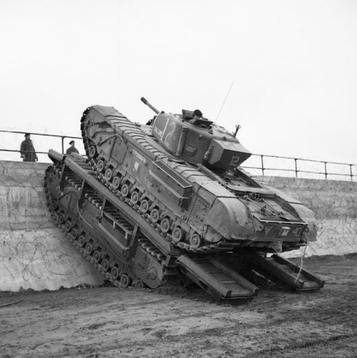 TheWorldatWar2's tweet image. A British Churchill tank from the 79th Armoured Division practiced using a Churchill Ark bridge setter to scale a sea wall - Saxmundham, Suffolk, England 11th March 1944. Photo : IWM #saxmundham #Suffolk #england #churchill #tank #training #ww2