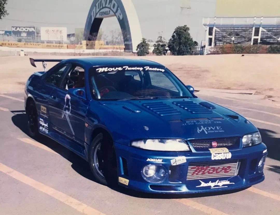 CarSighting's tweet photo. "Ever heard of MOVE TUNING FACTORY in japan?"
That's what some guy innocently asked on a forum in 2009. He had just picked up a 1995 R33 V-Spec, felt like it was an absolute rocket, and couldn't figure out what that weird sticker on his ECU was.

Move Tuning Factory was a Japanese tuner based in Hino, Tokyo, primarily known for the Skyline GT-R. In 1997 they claimed the fastest Skyline in Japan, their brochure was simply titled "Over 200MPH".
Square reached out to them for Racing Lagoon in 1999. Their demo car appears in the game. The Racing Lagoon logo sits on their real cars in return.