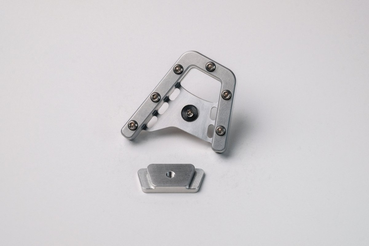 MoonlightLuke's tweet photo. I just finished my latest CNC project:

A motorcycle brake pedal enlarger with a custom bottom plate/nut. Since one of the sides is angled I couldn't just clamp it back into the vise after milling the top and side features, so I also had to make a custom fixture plate as well. https://t.co/JXFhWbDx1S