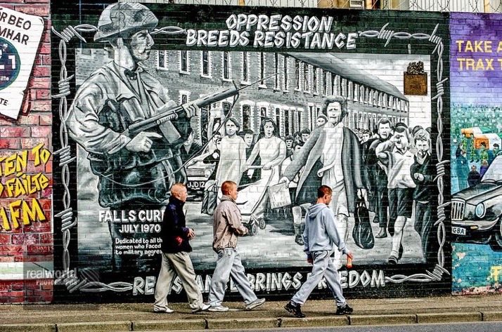 RealWorldImage's tweet image. Locals walk past a mural on the Falls Road. Belfast, Northern Ireland. Gary Moore photo. Real World Photographs. #Belfast #streetphotography  #NorthernIreland  #history #conflict #Nikon #documentary  #streetphotography #photojournalism #garymoorephotography #realworldphotographs