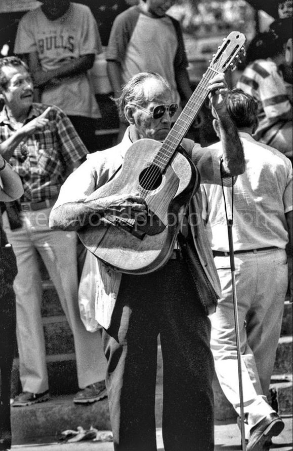 RealWorldImage's tweet image. A blind busker entertains market goers. San Salvador, El Salvador, Central America. 1993. Gary Moore photo. Real World Photographs. #Grok #streetphotography #blackandwhite #Nikon #Google #Grok #photography #photojournalism #ElSalvador  #realworldphotographs #garymoorephotography