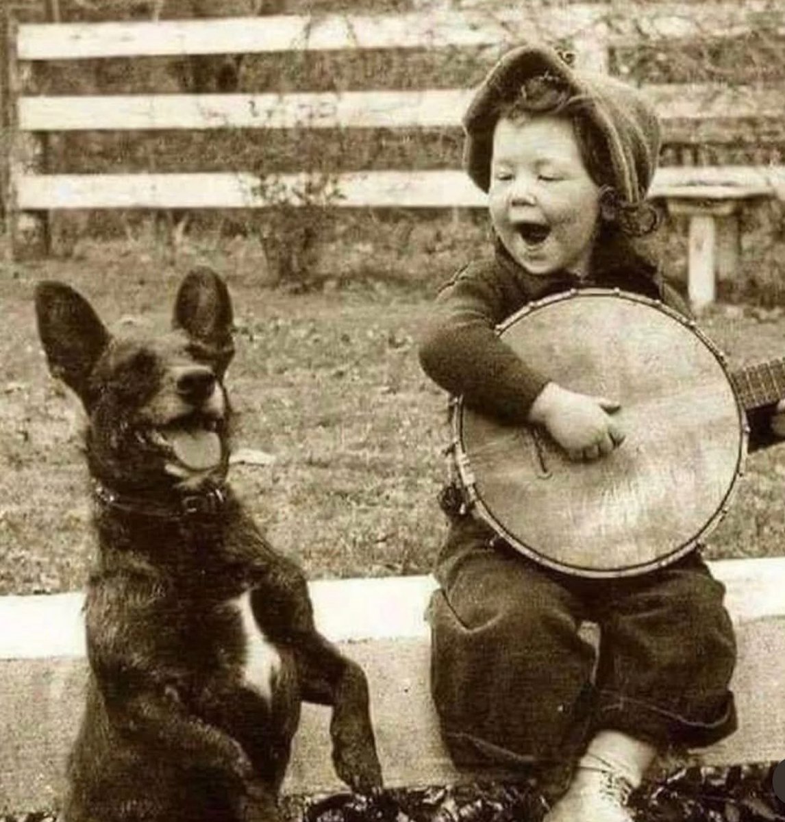 Young boy playing Banjo with his dog, 1920